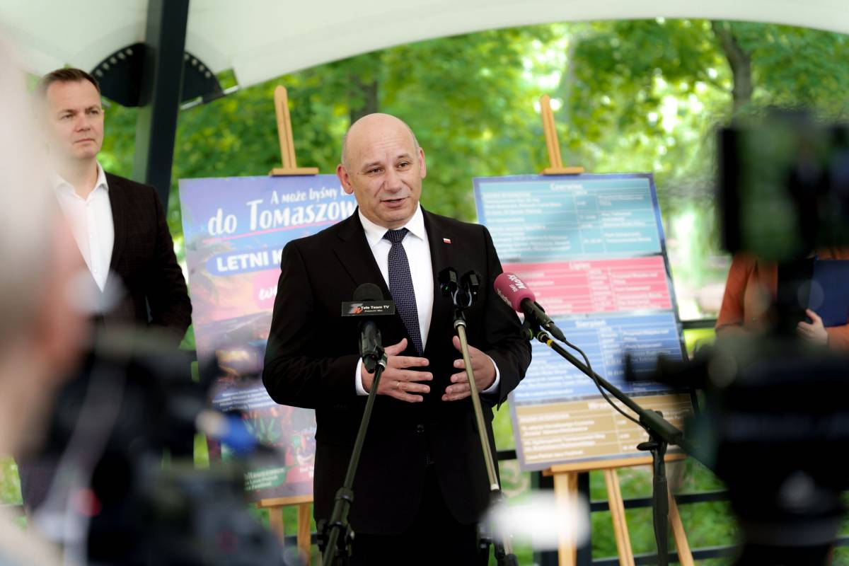 Na zdjęciu prezydent miasta stojąc na scenie amfiteatru muszla przedstawia letni harmonogram imprez kulturalnych, sportowych i rekreacyjnych. Za nim zastępca prezydenta i plansze z harmonogramem. Wydarzenie odbywa się podczas konferencji prasowej
