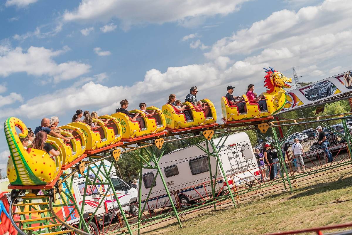 Na zdjęciu rollercoaster w kształcie smoka, z którego korzystają dzieci i rodzice podczas Pikniku Rodzinnego Dni Tomaszowskiej Rodziny