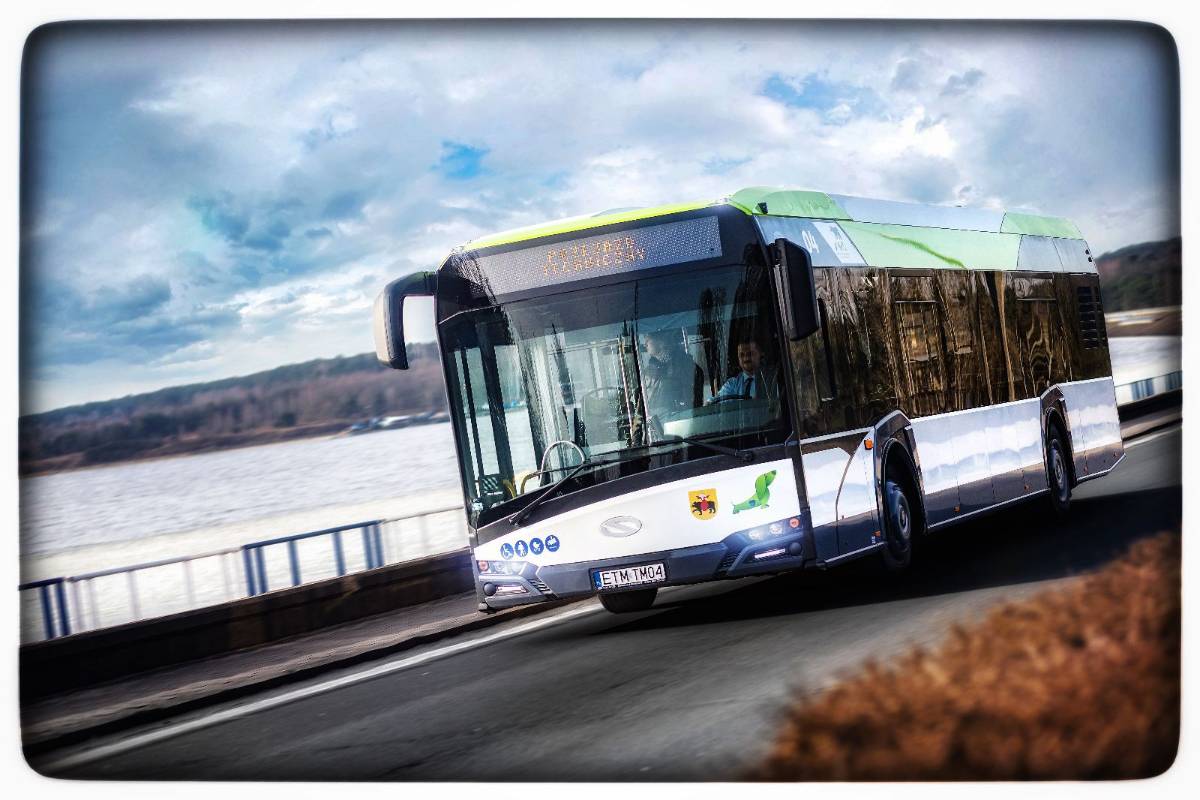 Na zdjęciu autobus MZK przejeżdżający przez tamę Zalewu Sulejowskiego, widać zbiornik wodny w tle i lasy