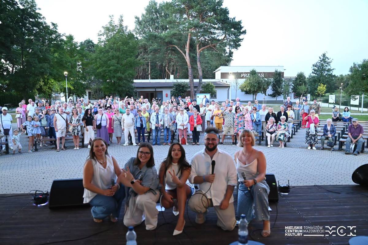 Na zdjęciu grupa Voice Ekipa podczas koncertu na letniej Scenie Artystycznej> Artyści pozują do fotografii na scenie, za nimi publiczność w amfiteatrze