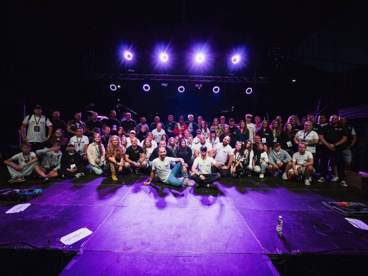 Na zdjęciu organizatorzy i artyści, którzy zorganizowali wydarzenie Nocna Jazda Motoshow 2026 w Tomaszowie Mazowieckim. Wszyscy pozują, stojąc w trzech rzędach na scenie na Tomaszowskich Błoniach