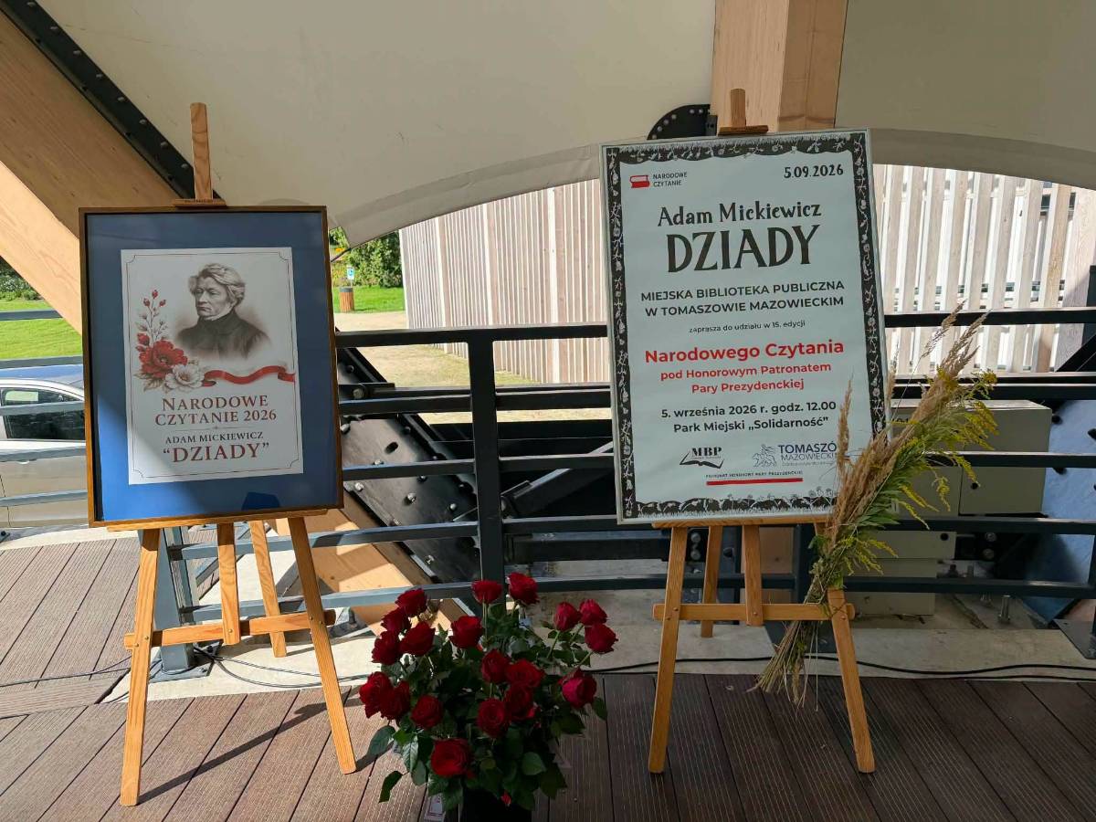 Muszla w Parku Solidarność. Na deskach sceny stoją dwie drewniane sztalugi. Na jednej zdjęcie Adama Mickiewicza, na drugiej biały plakat informacyjny z informacjami dotyczącymi wydarzenia. Między sztalugami, na podłodze bukiet czerwonych róż w wazonie.
