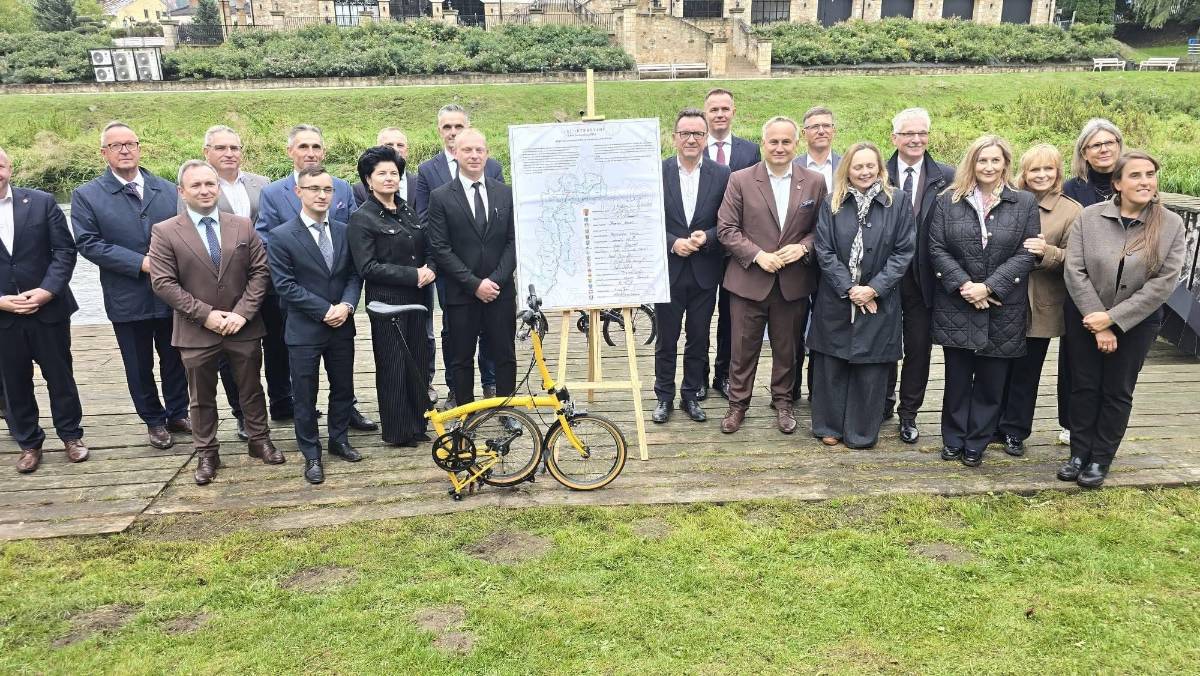 Na zdjęciu sygnatariusze listu intencyjnego w sprawie utworzenia trasy rowerowej o znaczeniu wojewódzkim „Velo Pilica”. Stoją na pomoście nad rzeką w miejscowości Przedbórz.