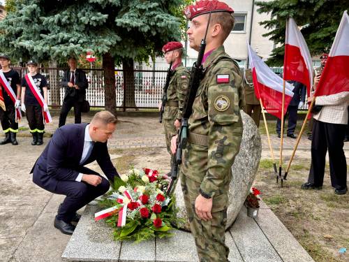 Zastępca prezydenta Tomasza Mazowieckiego składa kwiaty przed obeliskiem  upamiętniającym Sybiraków zamordowanych, zmarłych i zaginionych w Rosji Carskiej i Sowieckiej w latach 1768–1958. W tle flagi narodowe i inni uczestnicy uroczystości