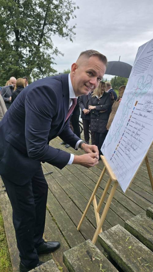Tomasz Migał zastępca prezydenta miasta Tomaszowa Mazowieckiego podpisuje list intencyjny powiększony i wyeksponowany na tablicy na tablicy