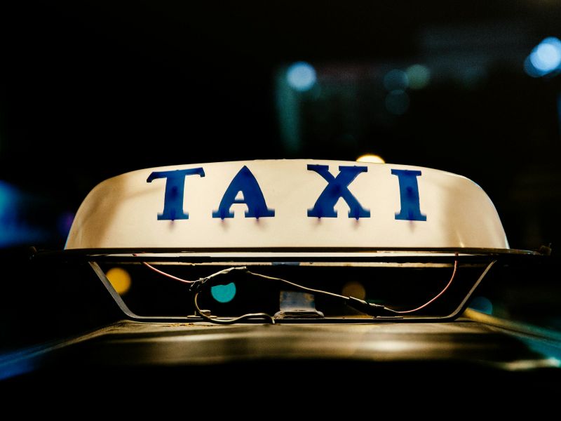 Na zdjęciu neon TAXI na taksówce