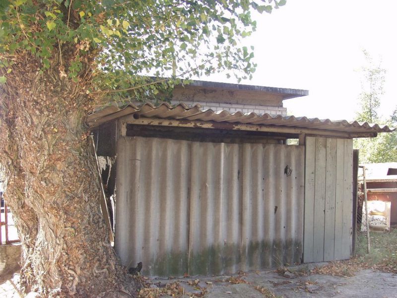 Na zdjęciu stary garaż z azbestowymi ścianami i dachówką