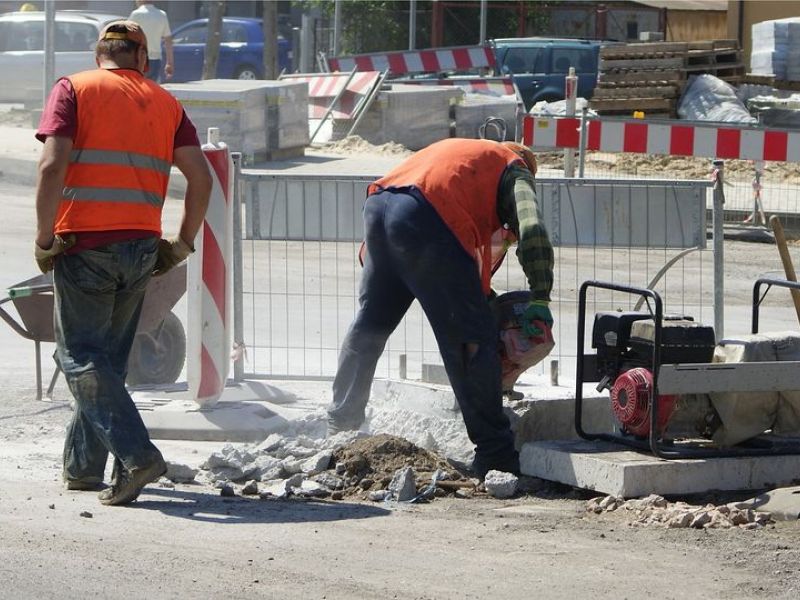 Na zdjęciu roboty drogowe. Drogowcy wykonujacy prace przy użyciu narzędzi do prac drogowych: młot, taczki itp.