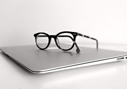 Na zdjęciu laptop, na laptopie okulary