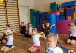 Na zdjęciu dzieci ćwiczące na sali gimnastycznej, korygują wady postawy